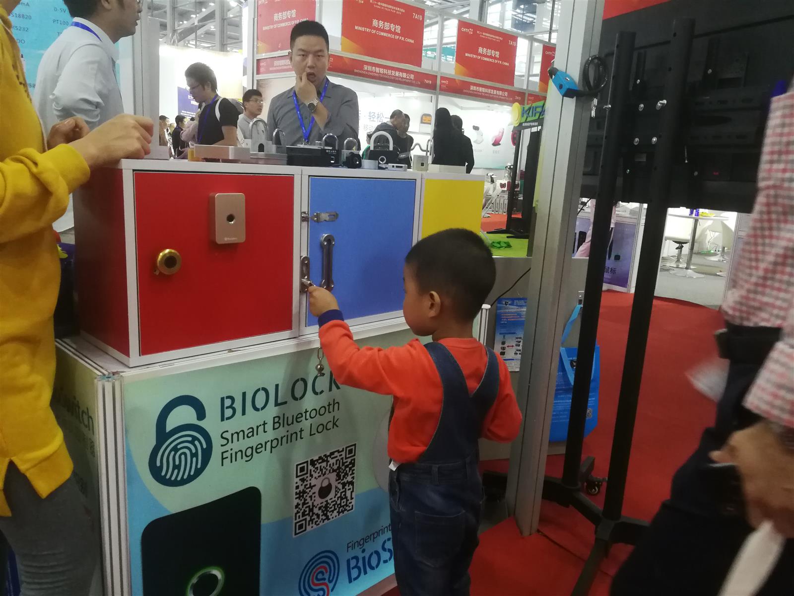 Visitor trying a BioLock fingerprint padlock during a live product demonstration